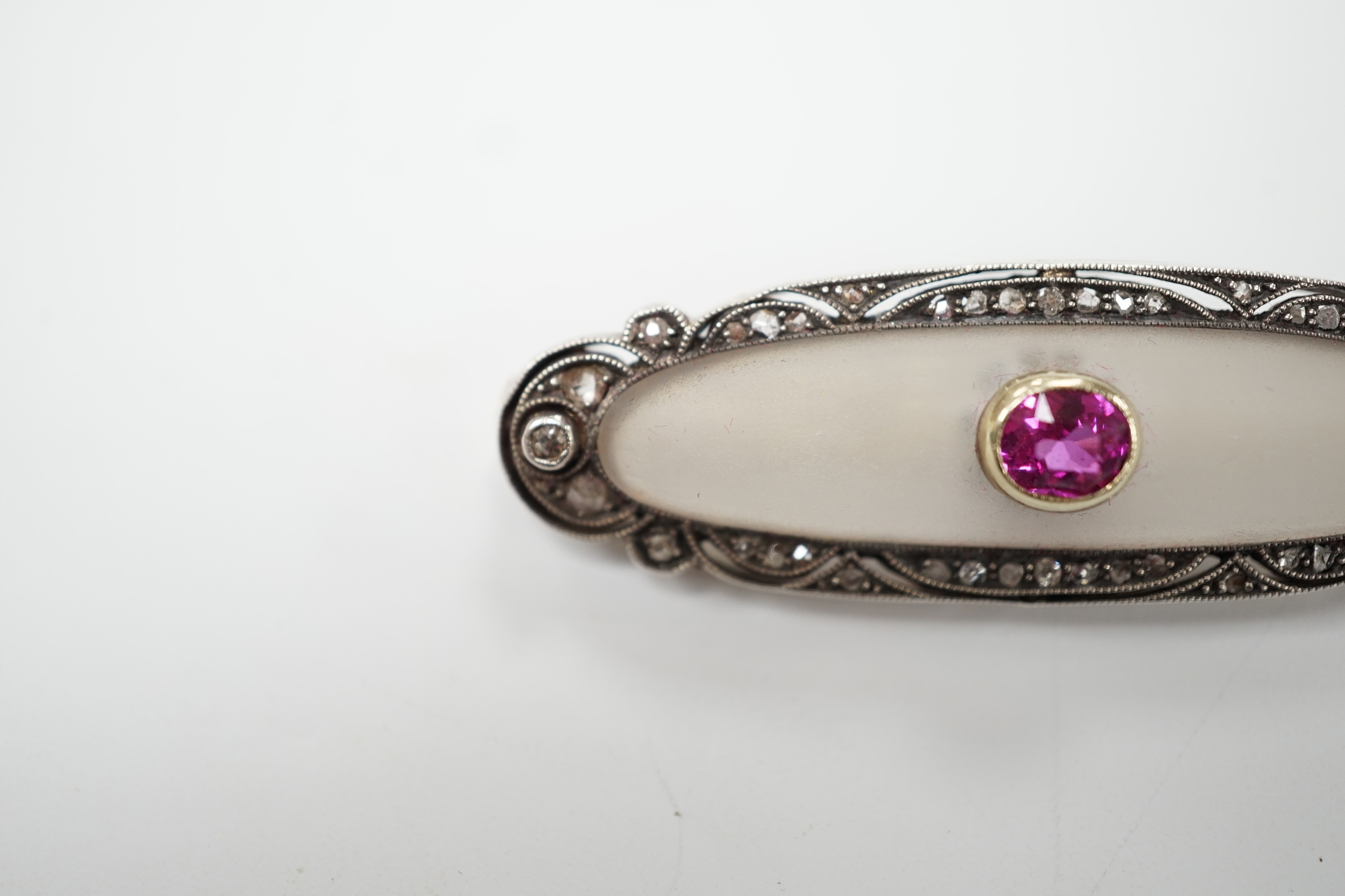 A 1920's yellow metal, diamond and single stone pink sapphire set rock crystal oval brooch, 48mm, gross weight 7.7 grams. Good condition.